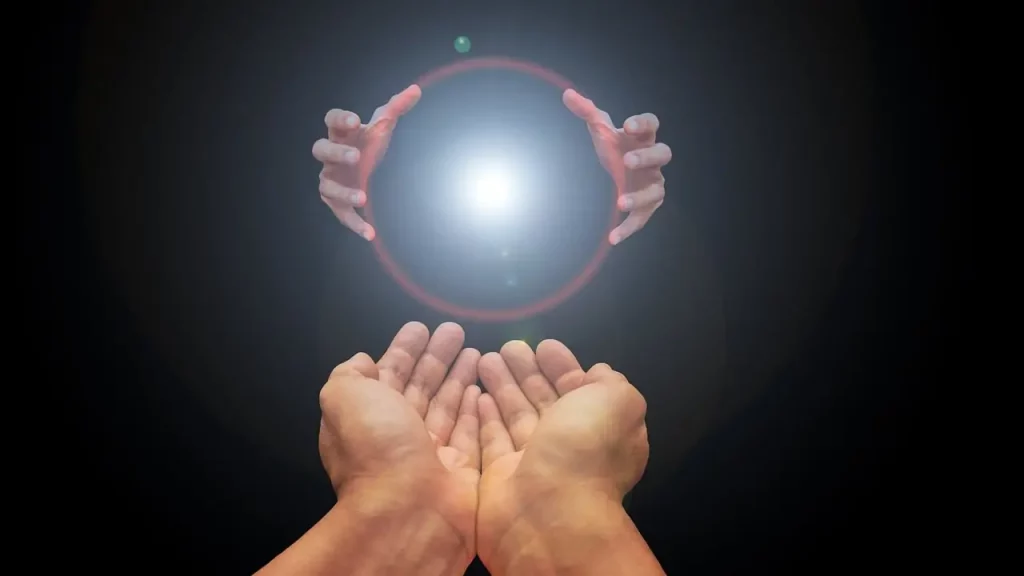 Dans cette image émouvante, deux paires de mains se rejoignent, formant un pont entre deux mondes. Une sphère lumineuse, chargée de significations, est délicatement transmise d'une paire de mains à l'autre, symbolisant le passage d'une vie à l'autre. C'est un moment de transition sacré, où les âmes se connectent et se transmettent la lumière de l'expérience et de la sagesse. C'est un rappel poignant de la continuité de la vie et de la connexion intemporelle entre les êtres